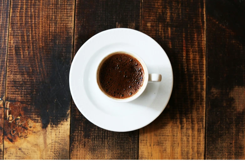 a cup of coffee with black liquid in a saucer