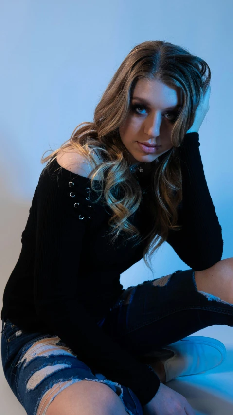 a beautiful young woman sitting on the floor posing for a pograph