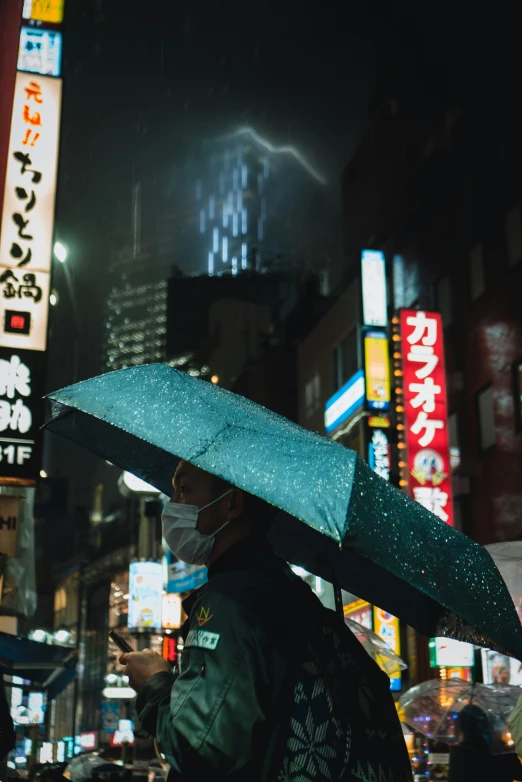 a man holding an umbrella with lights in the background