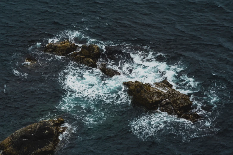 some rocks that are in the water near each other