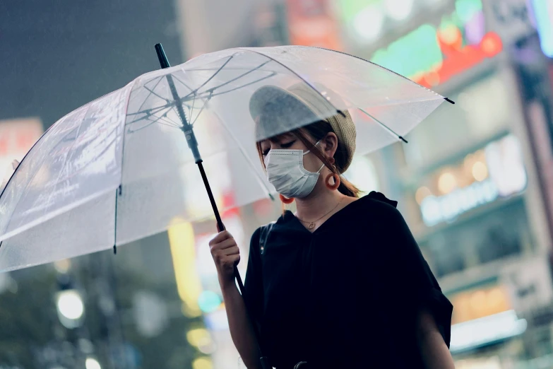 woman wearing a face mask and holding a umbrella