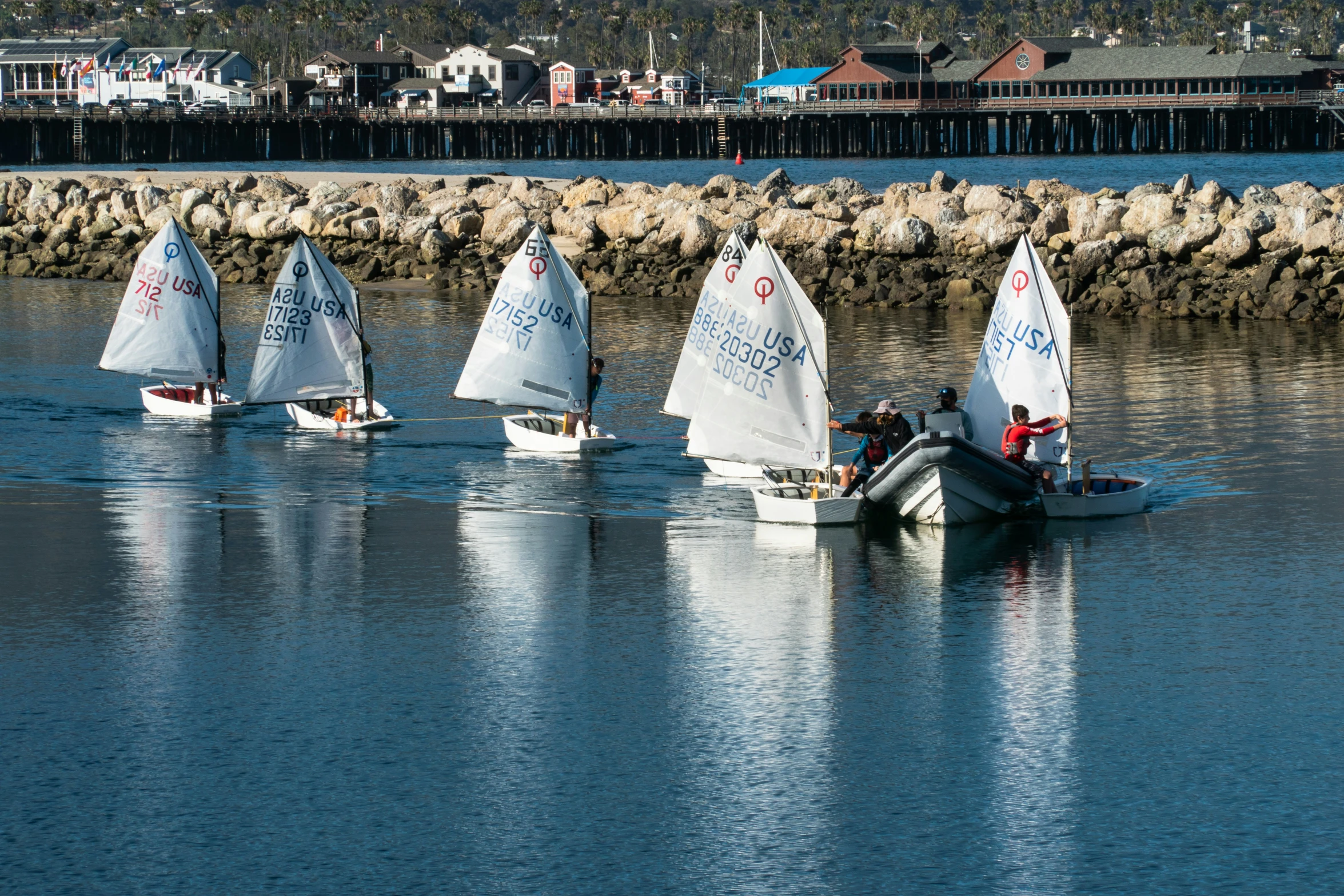 a group of boats in the water near rocks