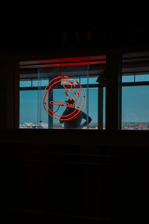 an illuminated sign is visible behind a window