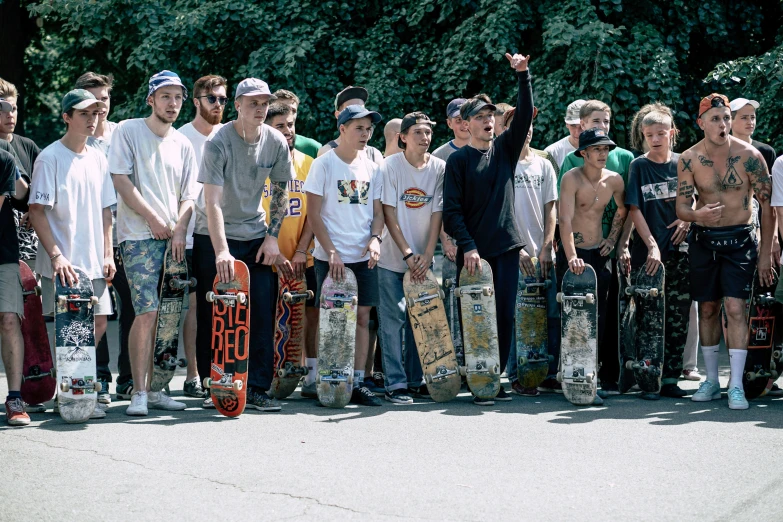 a group of men are standing outside with skateboards