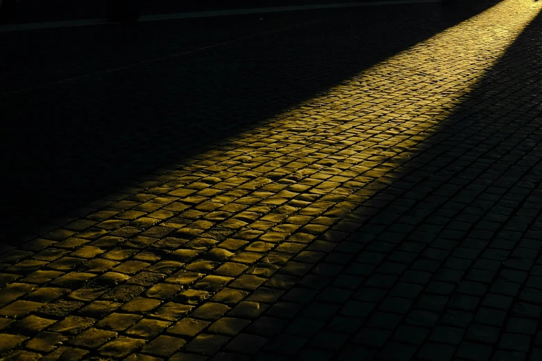 shadows cast on an outdoor brick walk and street