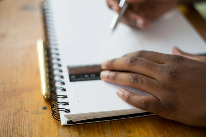 a woman writing on paper while holding a pen