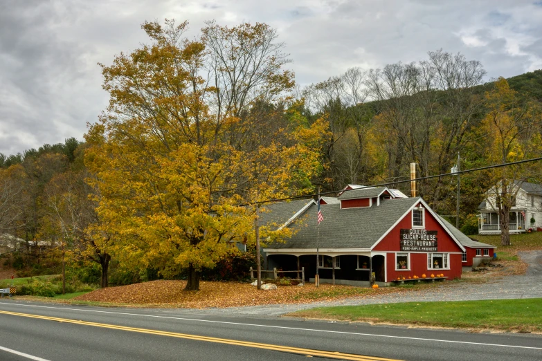 an old red house sitting on the side of a road