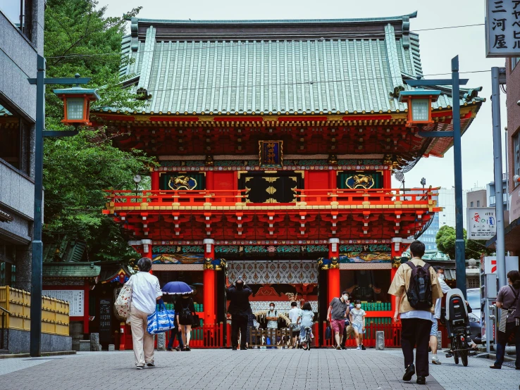 people walk under a pagoda with asian decorations