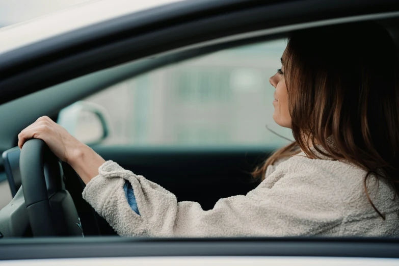 woman sitting in a car using a steering wheel