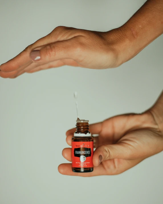 two hands holding an medicine bottle on a white background