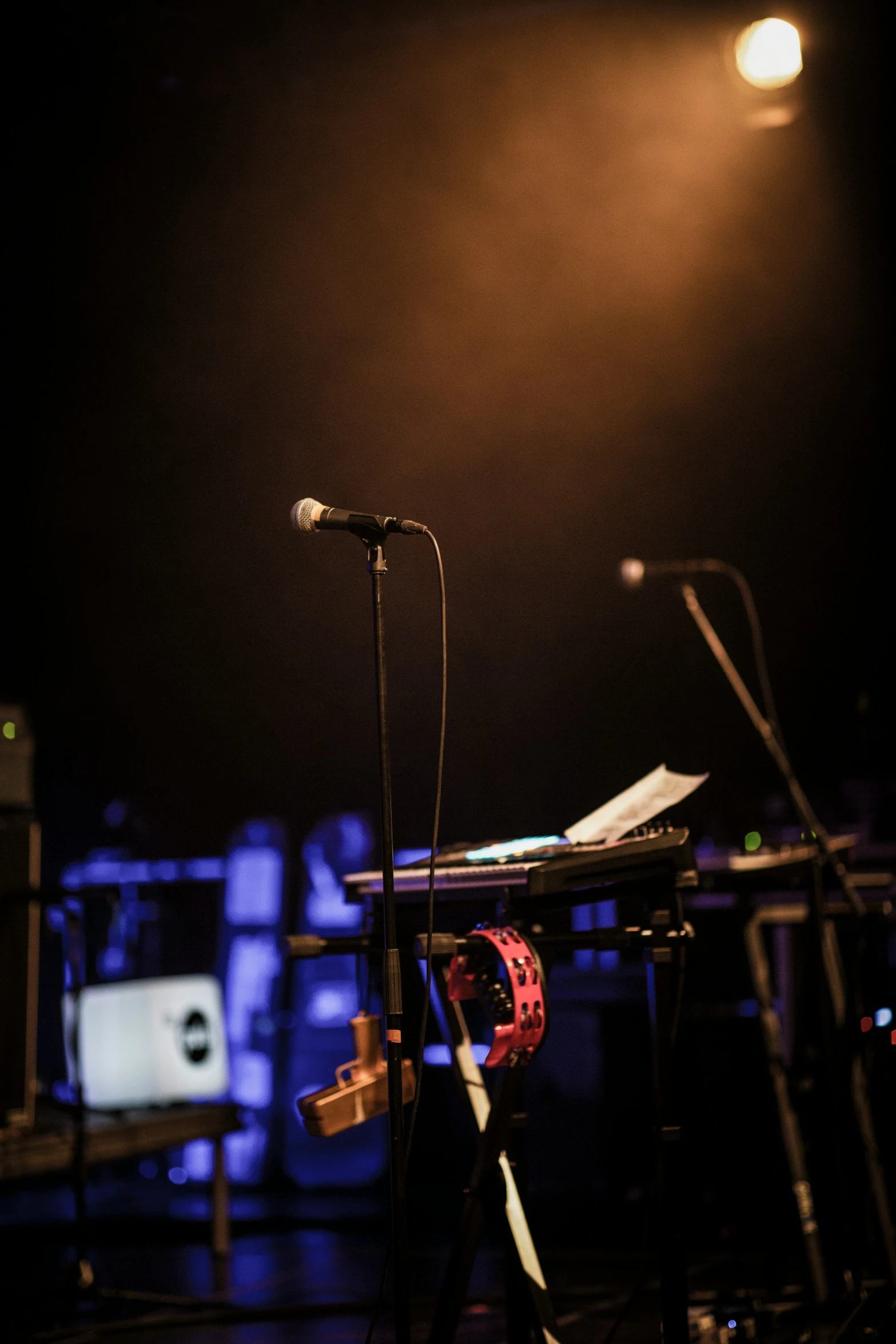 a keyboard and microphone on stage in front of a light