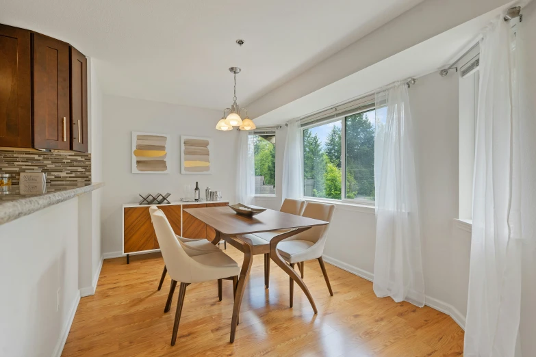 an elegant dining room with hardwood floors and lots of windows