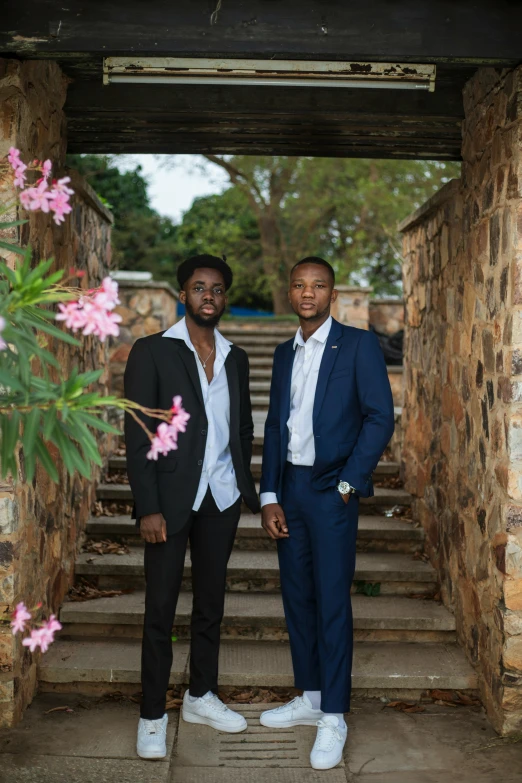 two men in suit and bow ties standing in an archway