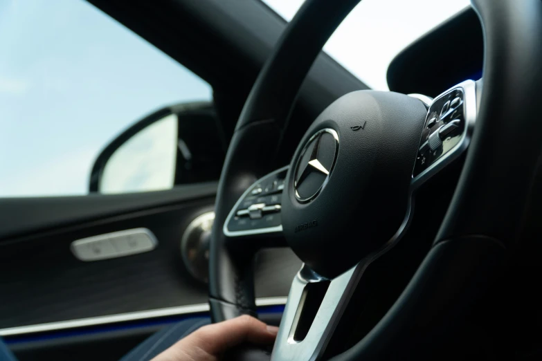 a person holding the steering wheel wheel controls