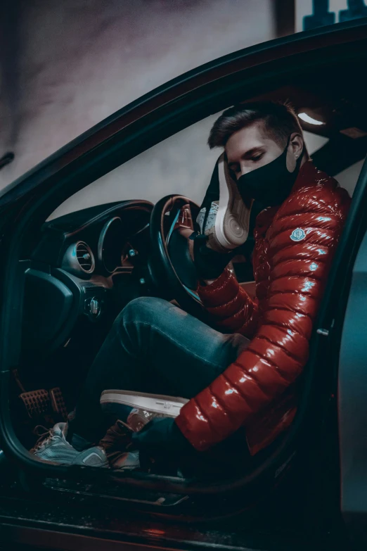 a man in a red jacket driving a car