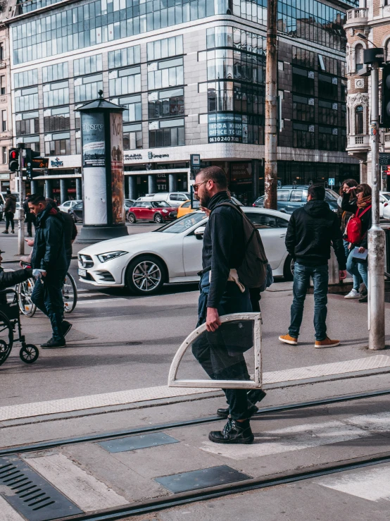 a man on a street corner standing next to a train