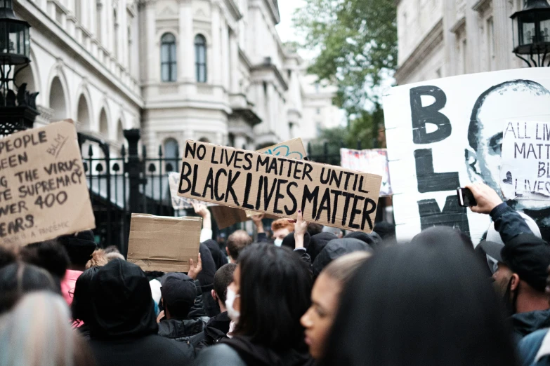 people holding signs in front of buildings with protest signs