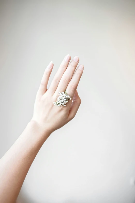 a woman holding up her hands with two rings on them