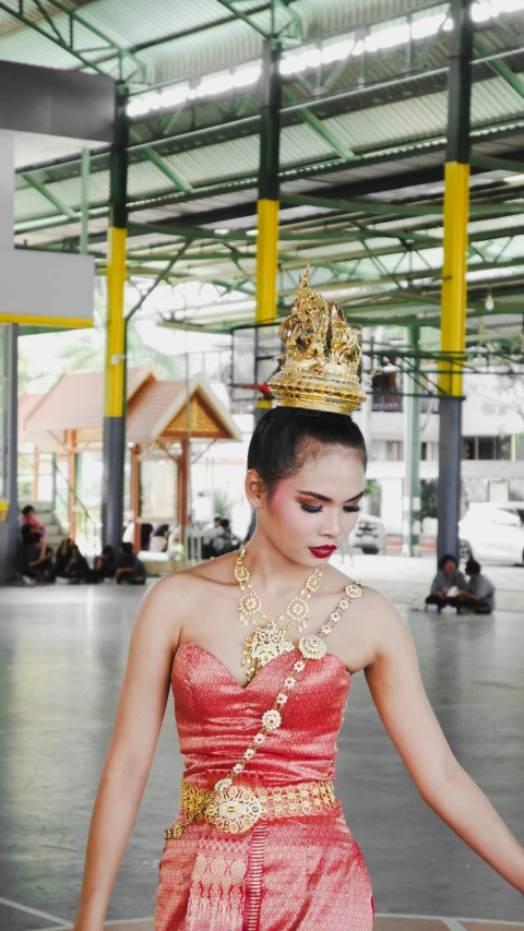 an oriental woman in red dress holding a large item in her hand