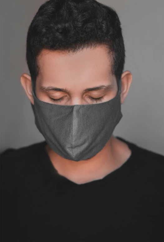 a young man wearing a black cloth mask