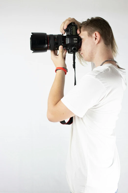 a man in white shirt holding camera up to his face