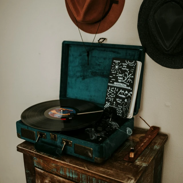 an old suitcase is set on top of a table with a record player