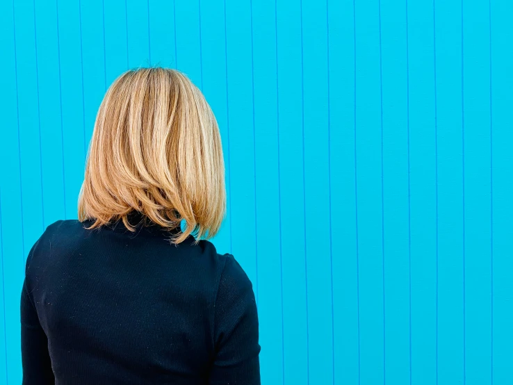 a person standing against a blue wall