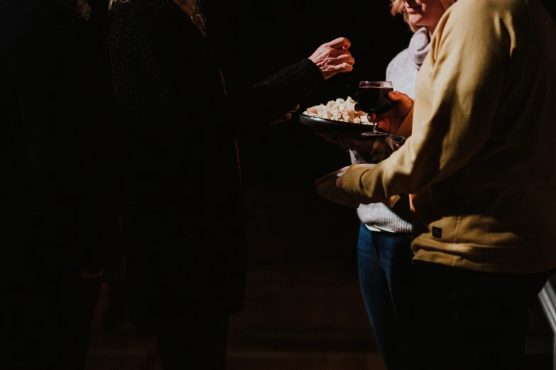 two women are standing with some food in their hands