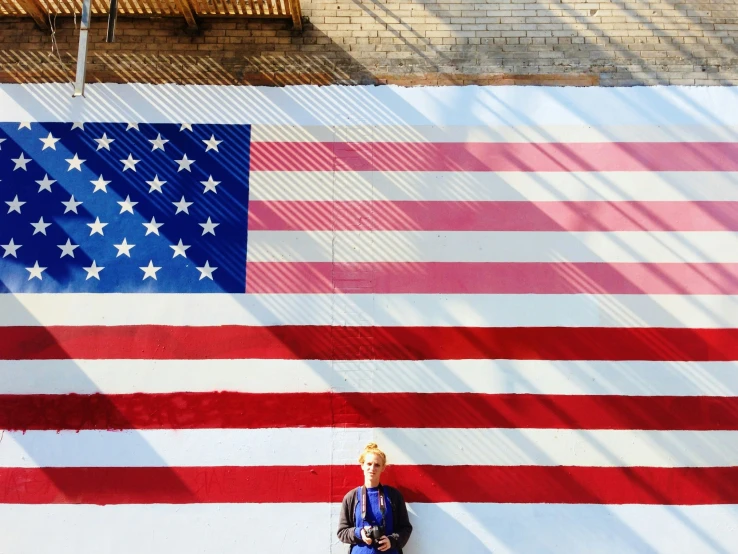 a person sits in front of a huge flag