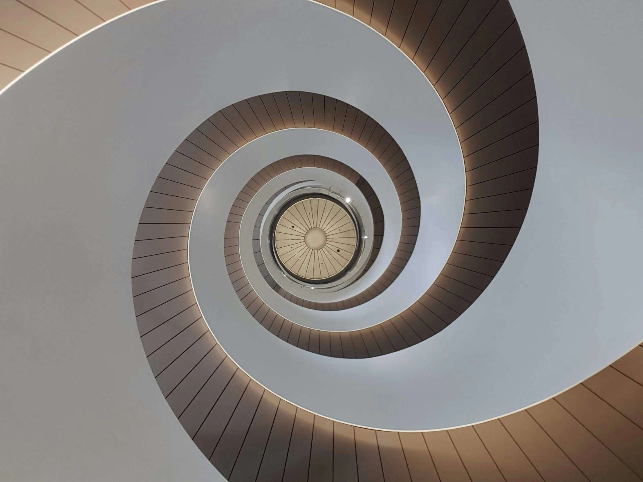 looking up at a spiral stair at the top of a building