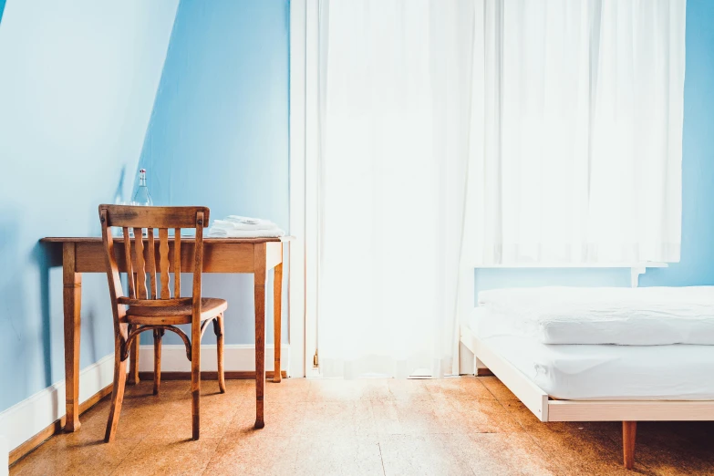 a bedroom with wooden floors and blue walls