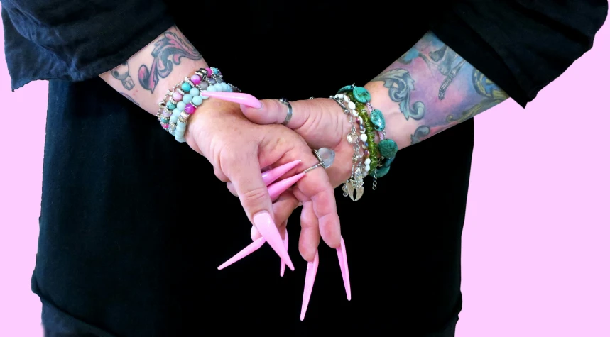 a tattooed woman holding onto a pink object with her hands