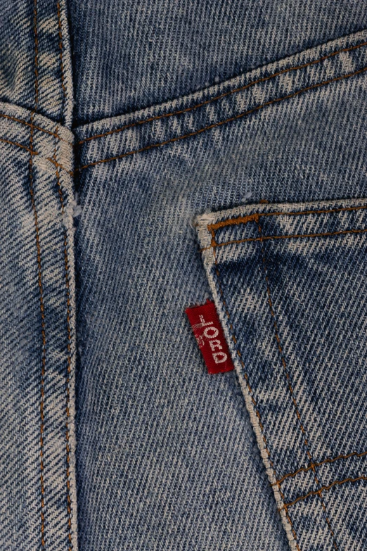 the back pocket of a blue jean pants with a red tag