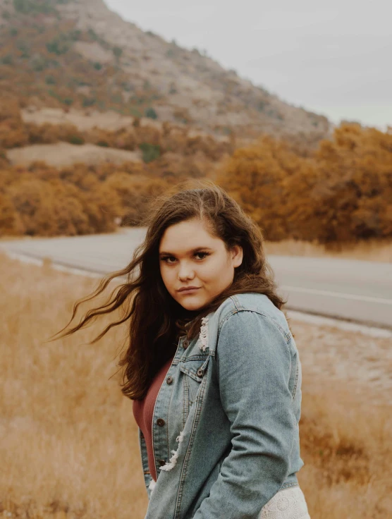 a woman in a jacket standing near the road