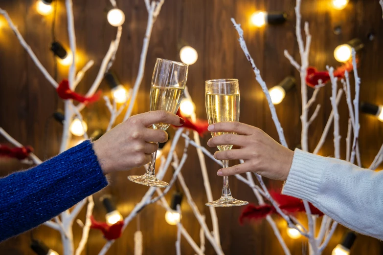 a couple holding glasses of wine near a tree