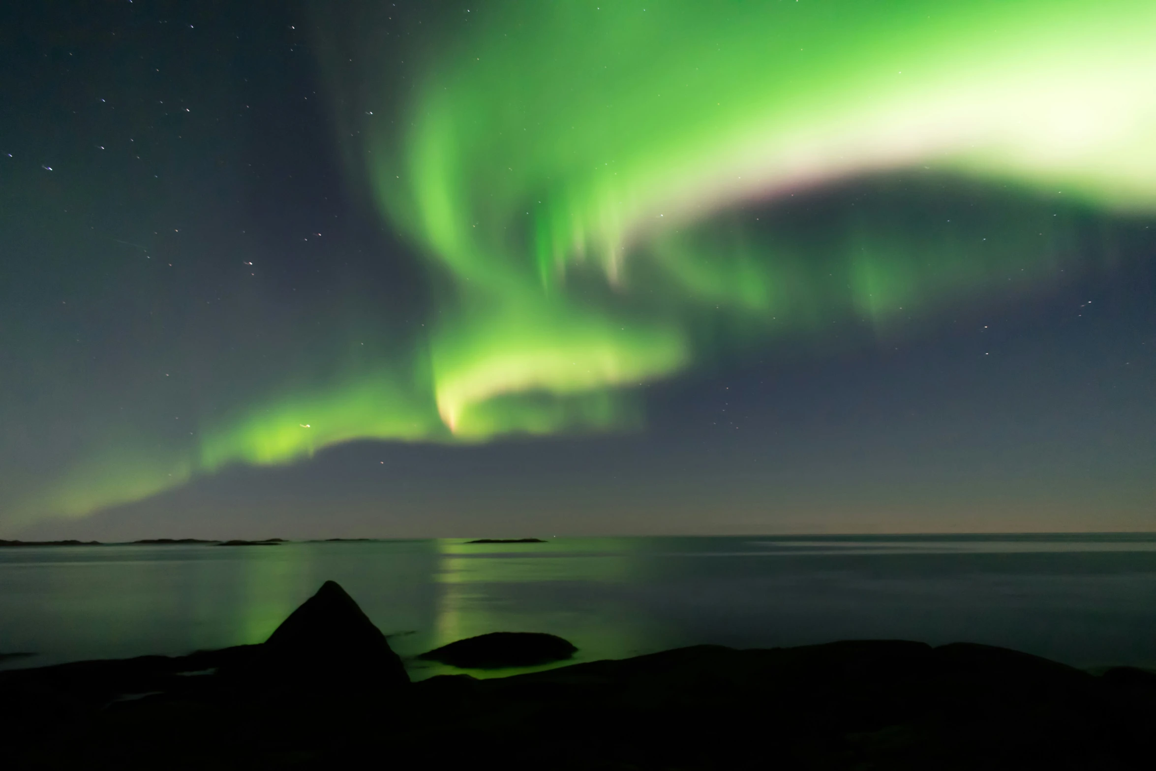 the aurora is lit up and shining bright in the sky