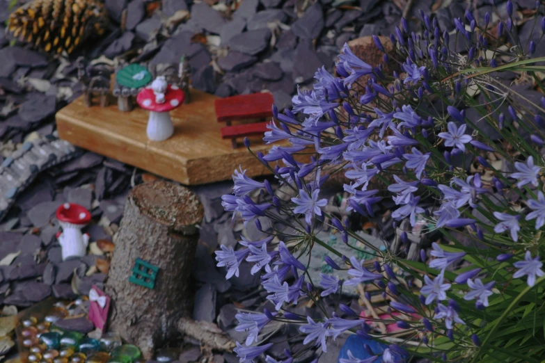 purple flowers and fairy figurines on the ground