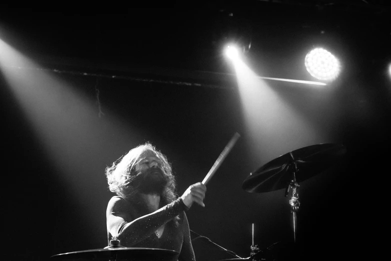 a woman with a band on stage playing drums