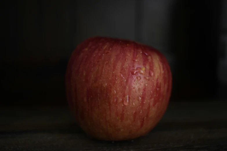 a close up po of a red apple with water droplets