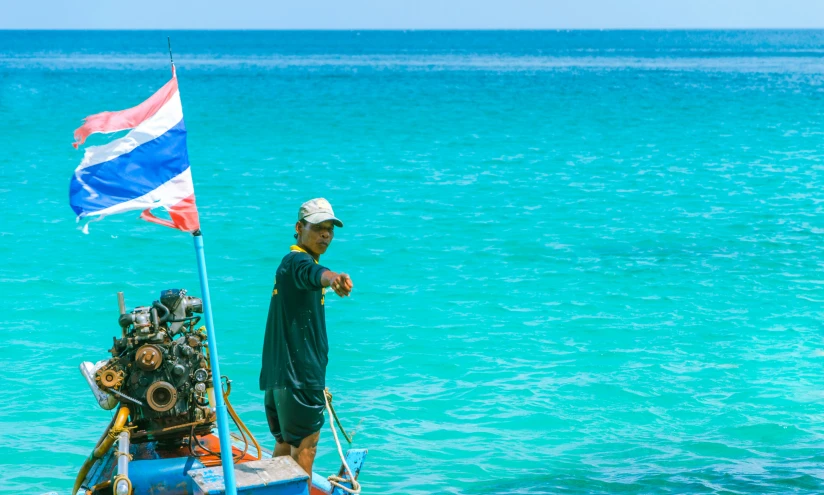 a man stands in front of a boat with gear strapped on it