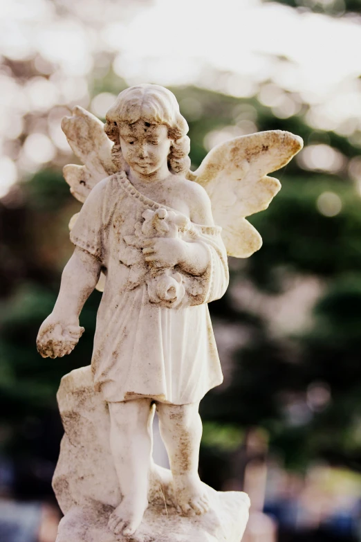 statue of a white angel holding a bouquet of flowers