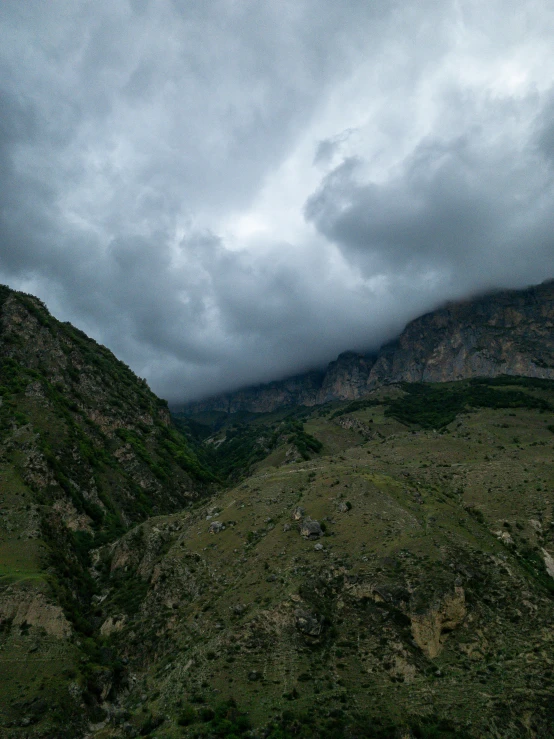 the dark sky with some fluffy clouds over a mountain