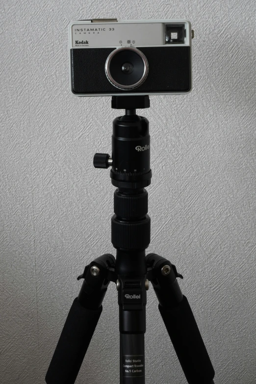 a camera sitting on a tripod in front of a wall