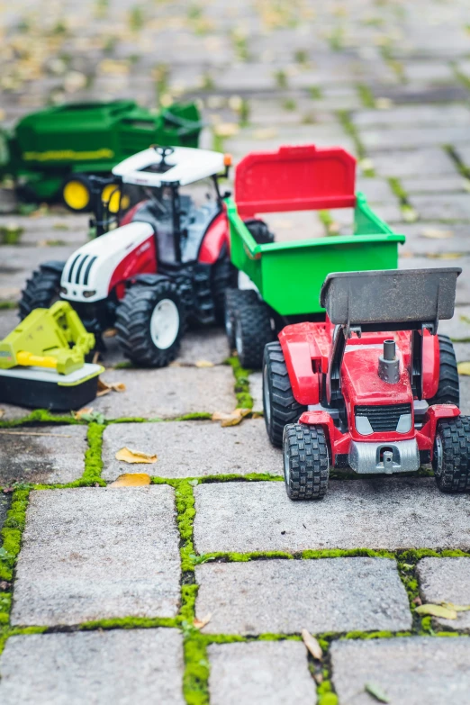 small toys and tractor on cobblestones on a cobblestone surface