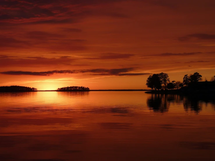 a sunset with an overcast sky reflected on the water