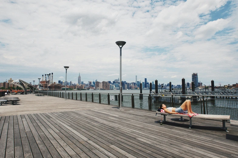 woman taking a nap on a bench at the pier