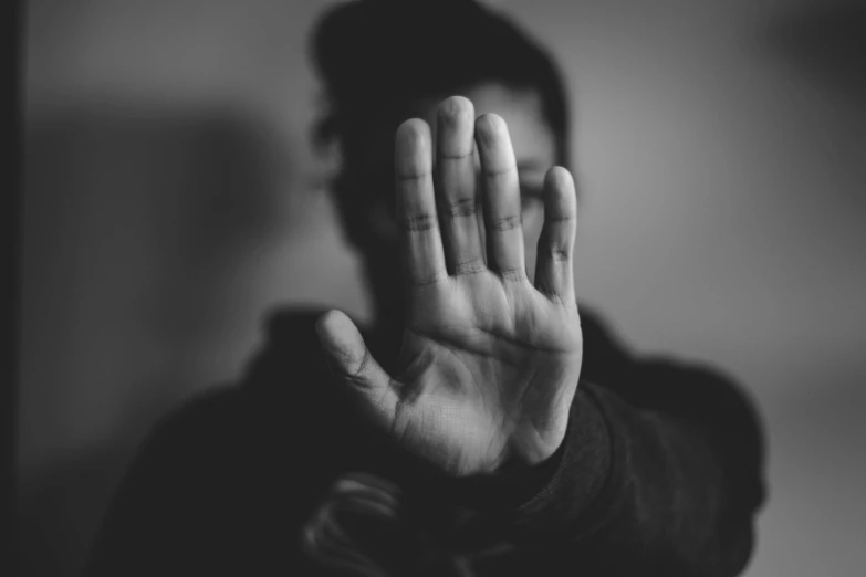 man in glasses with hands raised up to the camera