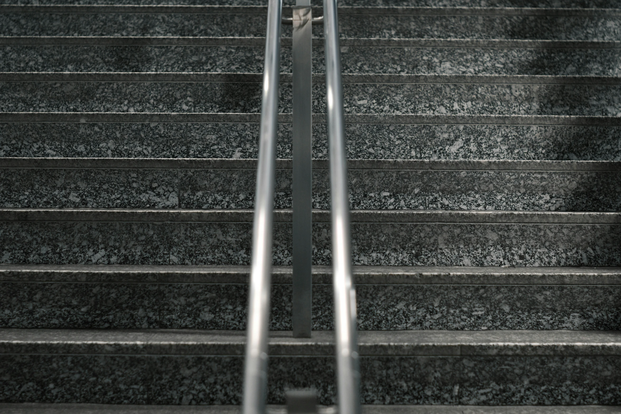 the bottom of a stairwell with metal hand rails