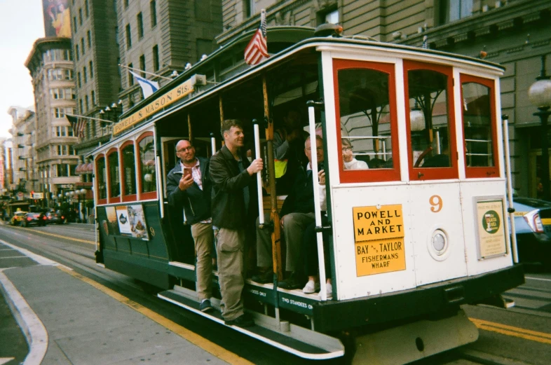 some people riding on the back of a trolley car