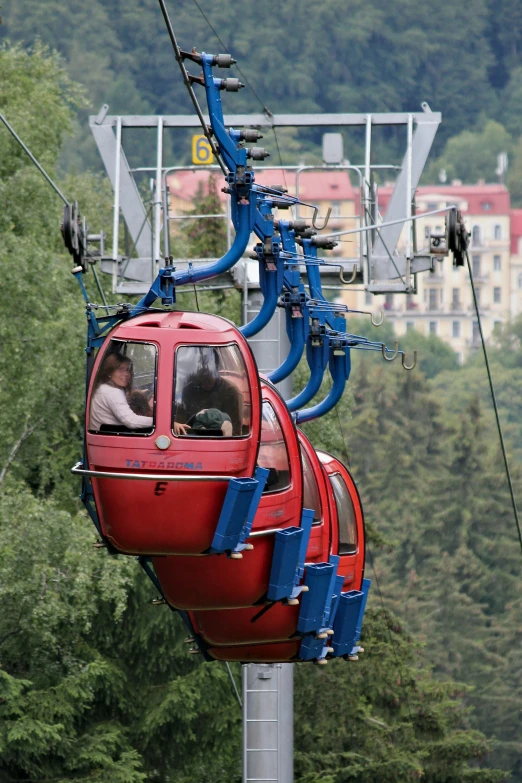 an electric cable car with two passengers on the upper deck